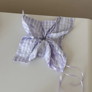 Close-up of lavender plaid fabric hair scrunchie with white lace trim and purple ribbons