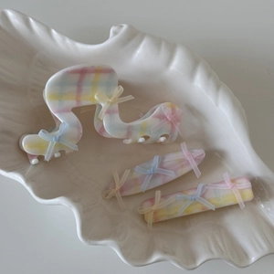 Détail d'un ensemble de pinces à cheveux à carreaux pastel avec des nœuds en ruban doux
