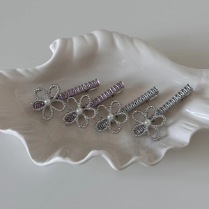 Elegant 4-piece pearl and rhinestone flower hair clip set on a white shell tray