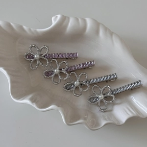 Detail of four-piece pearl flower hair clips with crystals on a white ceramic shell tray