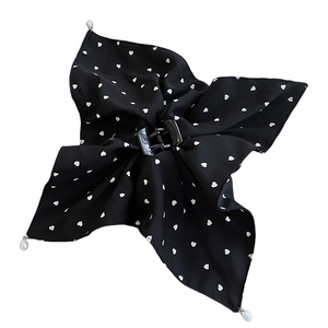 Élastique à cheveux noir à motif cœur avec nœud et perles sur fond blanc pur