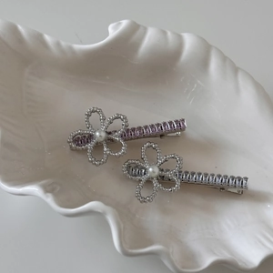 Detail of silver floral hair clips with pearls, purple and clear rectangular rhinestones