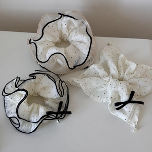 Détail de chouchous à pois blancs et nœud avec bordure en dentelle et perles