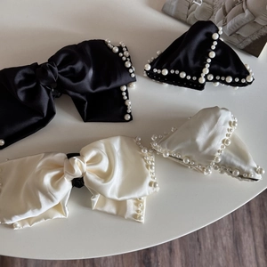 Set of satin bow hair claws and pearl-studded clips in elegant black and cream white
