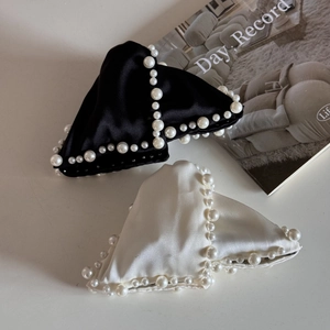 Close-up of elegant triangular satin hair claw clips with decorative white pearls