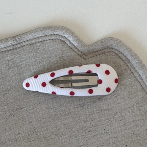 Detail of red polka dot fabric teardrop hair clip with silver metal BB clip attachment