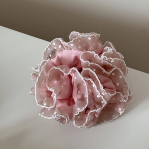 Détail du chouchou en tulle rose clair avec pois blancs et bordure en dentelle