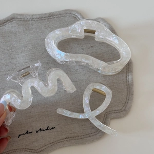 Dreiteiliges Set aus perlweißen Acetat-Haarklammern in verschiedenen eleganten Formen