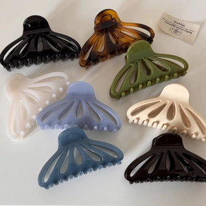 Detailed overhead view of eight assorted hollow fan-shaped claw clips in vibrant colors