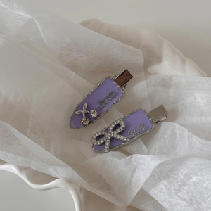 Vue détaillée de barrettes violettes avec nœud en strass et texte Barrette La France