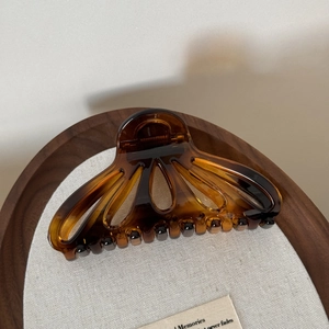 Macro detail of tortoiseshell fan-shaped hair claw with glossy finish and secure grip