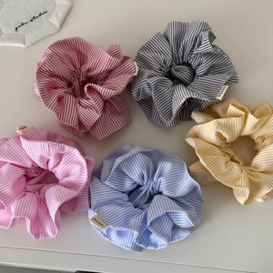 Vue détaillée de cinq chouchous en tissu rayé avec des étiquettes tissées à la main