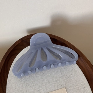 Detail of lavender translucent fan-shaped hair claw clip with hollowed petal design