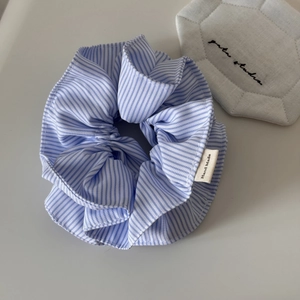 Détail du chouchou en tissu à rayures bleues et blanches avec étiquette Hand Made