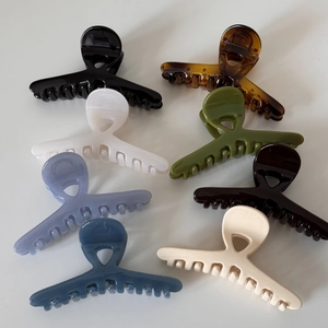 Set of 7 glossy crossed hair claws in assorted colors like amber black and olive green