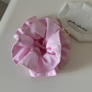 Détail d'un chouchou à rayures roses et blanches avec une étiquette faite main