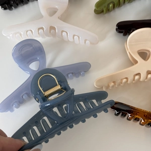 Close-up of elegant glossy crossover hair claws in diverse solid colors and amber patterns