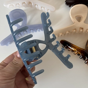 Macro detail of large glossy cross hair claw clip featuring durable metal spring mechanism