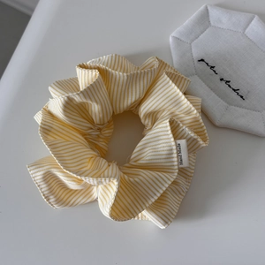 Détail du chouchou en tissu à rayures jaunes et blanches avec étiquette Hand Made