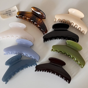 Top view of eight large glossy hair claw clips in assorted elegant retro colors