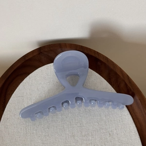Macro view of light purple translucent hair claw clip with smooth polished finish