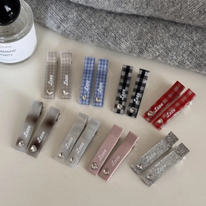 Détail de barrettes rectangulaires avec texte Love et strass en cœur aux motifs variés