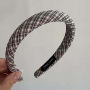 Détail d'un serre-tête vintage fait main avec tissu à petits carreaux et étiquette