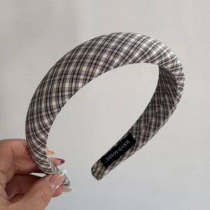 Vue détaillée d'un serre-tête à carreaux gris fait main avec finition tissu et étiquette