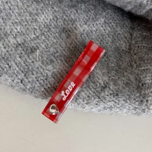 Détail de la barrette à carreaux rouges et blancs avec inscription Love en blanc