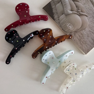 Close-up of five medium acetate hair claws with colorful rhinestones in various shades