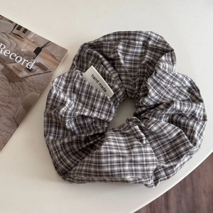 Détail d'un chouchou à carreaux vintage gris avec étiquette faite main sur blanc