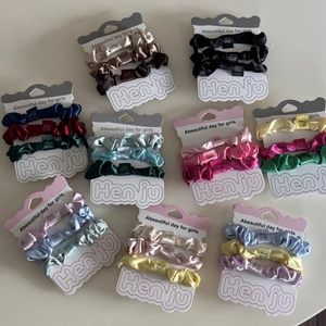 Detailansicht von neun Satin-Haargummi-Sets in verschiedenen Farben auf Karten