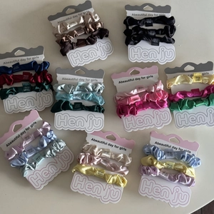 Detailset bunter Satin-Haargummis auf Kartonverpackung für vielfältige Frisuren und Styles