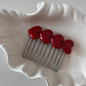 Detail of red heart acetate hair comb featuring France Handmade engraving on white tray