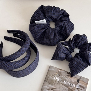 Flat lay of blue and black plaid hair accessories set including headbands and scrunchies