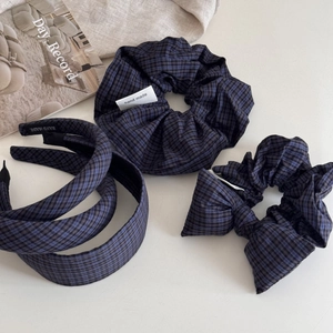 Close-up of blue and black plaid headband and matching scrunchie with handmade labels