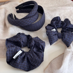Blue and black gingham padded headbands and hair scrunchies set on linen background