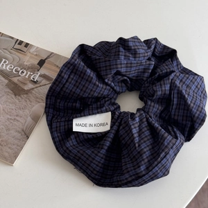 Close-up of blue and black gingham check scrunchie with Made in Korea label