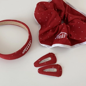 Détail de l'ensemble d'accessoires cheveux rouges à pois avec logo brodé emii