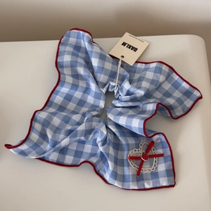 Detail of oversized blue checkered hair scrunchie with lace heart and strawberry charm