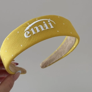 Détail du bandeau en tissu jaune avec pois blancs et broderie de lettres emii chic
