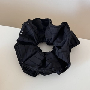 Detail showing black striped texture of a sheer mesh hair scrunchie for ponytails