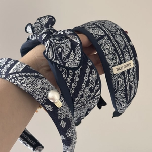 Detail of navy paisley scrunchie with lace edge, white pearl, and heart charm