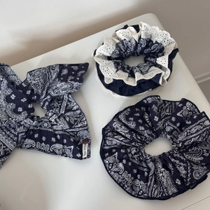 Detailed set of navy blue paisley print scrunchies with white lace and bow details