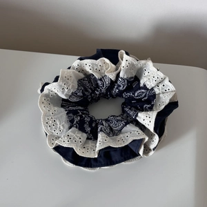 Detailed view of navy blue paisley scrunchie featuring elegant white lace embroidery