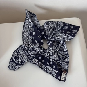 Detailed view of navy paisley scrunchie with lace edge and TRUE FITTED brand label