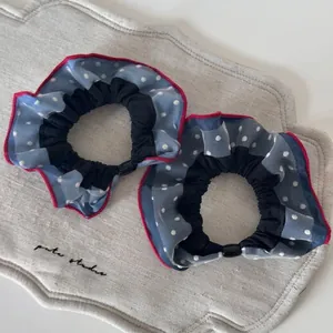Set of two blue polka dot fabric scrunchies with red ruffled edges for daily hair styling