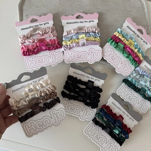 Set di quattro elastici per capelli in raso elasticizzato in vari colori su schede