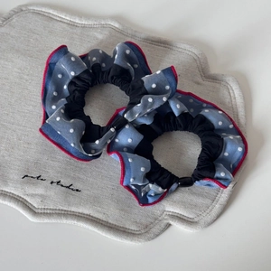 Detail of navy polka dot mesh scrunchies with red contrast stitching and elastic tie