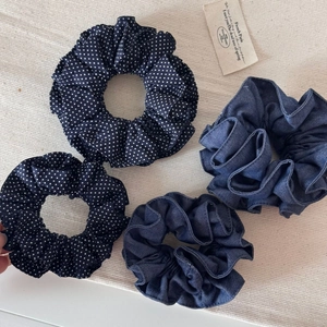 Lot de 4 chouchous en denim bleu et à pois blancs posés sur un tissu beige texturé élégant
